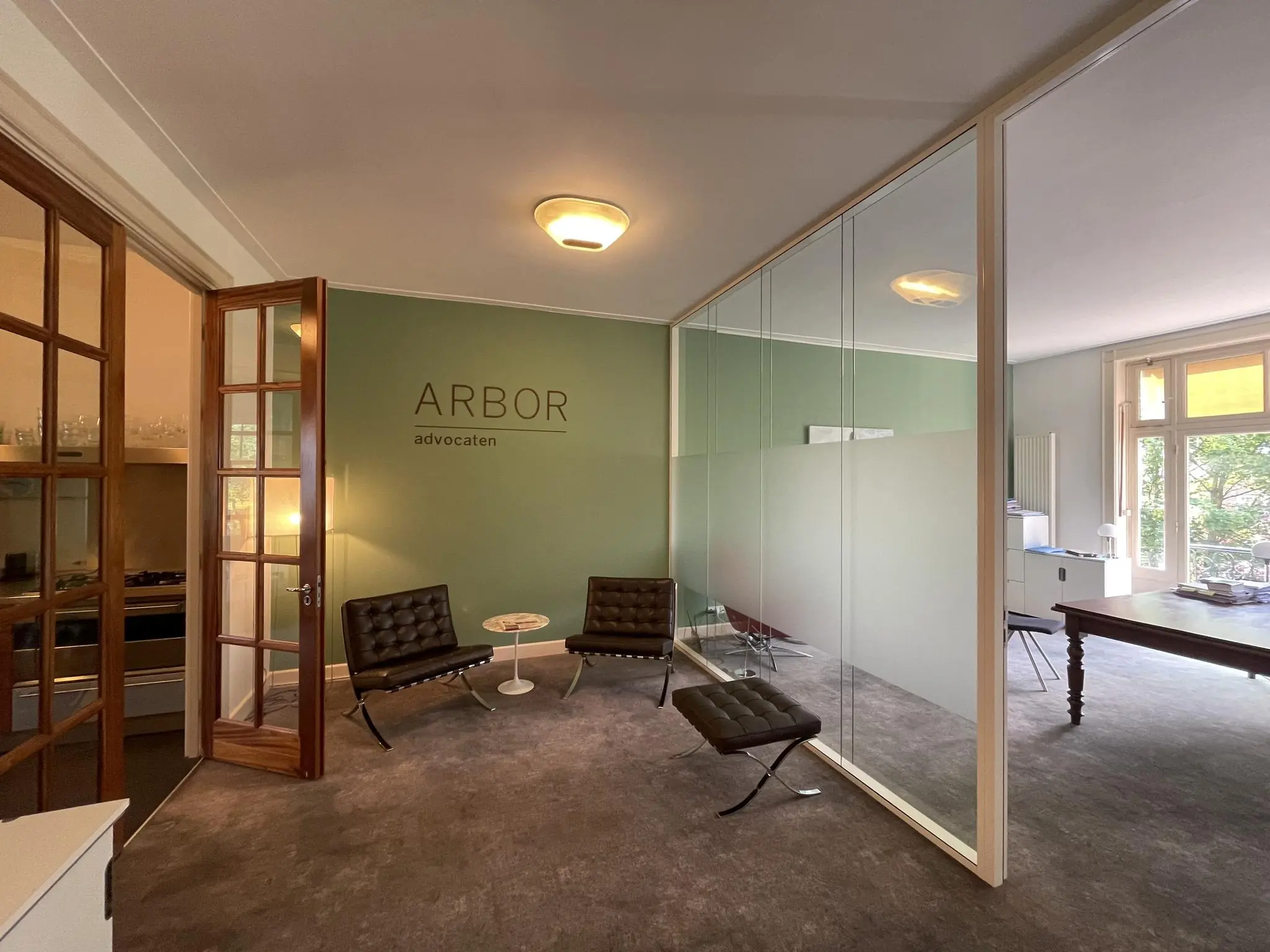 Wachtruimte van advocatenkantoor Arbor aan de Oranje Nassaulaan met moderne stoelen en glazen scheidingswand.